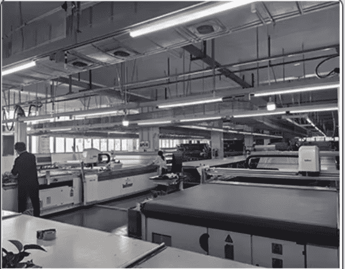 Precision fabric spreading and automated cutting table for athletic performance wear