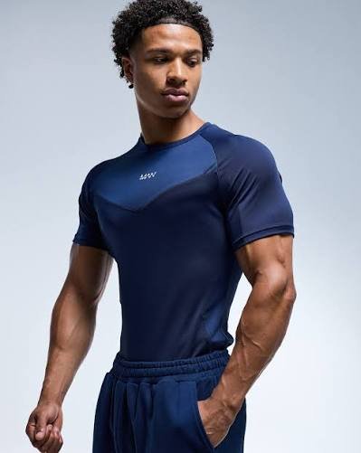 Athlete performing overhead barbell lift in raglan sleeve athletic training t-shirt