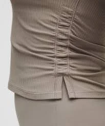 Close-up of reinforced attachment stitching at a stress point in an activewear top