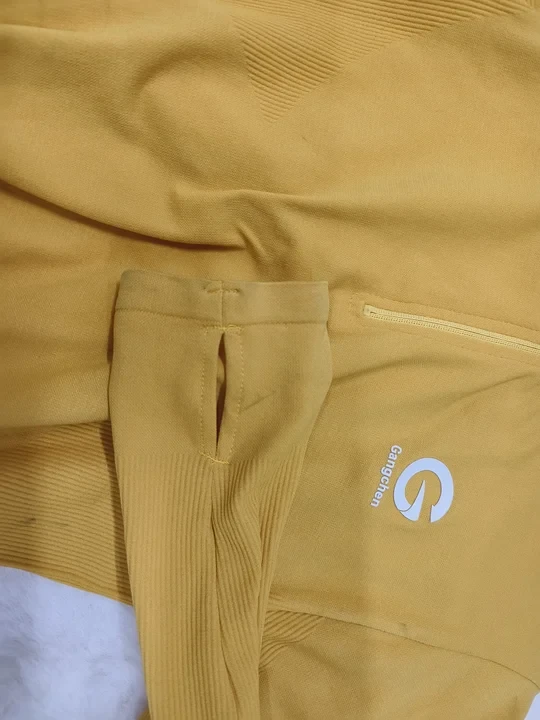 Construction close-up of a thumbhole opening and its finished edge on a seamless workout sleeve