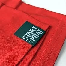 Woven brand label patch attached to the hem or side panel of a training top
