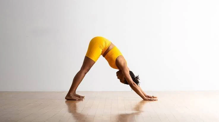 Fitted yoga crop in Downward-Facing Dog showing hem location and torso coverage