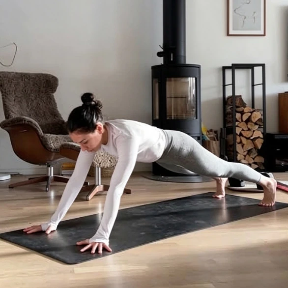 Yoga practitioner demonstrating a downward-facing pose for evaluating long sleeve neckline coverage and shoulder extension